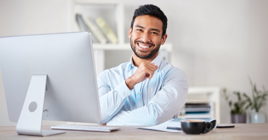Loan officer smiling at a desk beside a computer