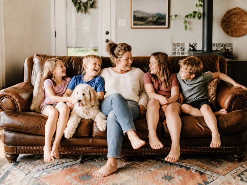 Family sitting on a sofa with a dog